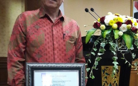 Kadis Perdagangan Koperasi dan UKM Kotamobagu Herman Arai saat menerima piagam penghargaan