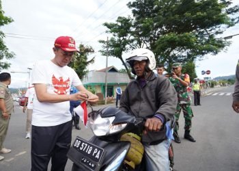 Bupati Bolaang Mongondow Selatn (Bolsel) Iskandar Kamaru memimpin pembagian ribuan Bendera Merah Putih kepada warga Kabupaten Bolsel. Pembagian tersebut untuk meningkatkan jiwa nasionalisme seiring peringatan Hari Ulang Tahun Kemerdekaan Republik Indonesia tahun 2022 ke-77. Pembagian Bendera itu melibatkan Forkopimda, serta para ASN bertempat di alun-alun ibu Molibagu Kecamatan Bolaang Uki Rabu 10 Agustus 2022. “Kami membagikan bendera merah putih kepada masyarakat. Ini adalah program Pemerintah Pusat  dengan bertajuk Indonesia 10 juta Bendera Merah Putih,” ujar Bupati Bolsel Iskandar Kamaru. Menurut Bupati, Bendera Merah Putih sebagai identitas, simbol dan alat pemersatu bangsa Indonesia agar semakin kuat. Selain itu untuk menggalang semangat partisipasi swadaya masyarakat agar semakin cinta Indonesia dengan mengibarkan Bendera Merah Putih. Selain memberikan kepada para pengendara, Bendera merah putih juga diberikan kepada Camat untuk dibagikan ke desa-desa. Bupati juga ikut memberikan bendera kepada pengendara yang lewat di lokasi acara. Bupati berpesan, seruan mengibarkan bendera di depan rumah warga harus terus digaungkan dan digelorakan. “Dengan semangat tema HUT ke-77 Kemerdekaan RI yaitu pulih lebih cepat, bangkit lebih kuat, kita kibarkan bendera Merah Putih dengan penuh semangat,” imbau Bupati. Iskandar juga menyampaikan, memperingati HUT RI ke 77, agar warga mengibarkan Bendera Merah Putih, sebagai bentuk rasa syukur dan terima kasih kepada para pejuang kemerdekaan dan meningkatkan nasionalisme, “Bendera Merah Putih di bulan Agustus harus berkibar sebulan penuh. Perjuangan merebut kemerdekan membutuhkan pengorbanan yang tidak sedikit. Saat ini kita tinggal mengisi kemerdekaan, dan mengibarkan bendera merupakan wujud nyata menghormati dan menghargai jasa-jasa para pahlawan serta sebagai bukti nasionalisme yang tinggi,” ungkap Bupati. Pemkab Bolsel bersama Forkopimda dan pimpinan instansi lainnya mewujudkan “Gerakan Pembagian 10 Juta Bendera Merah Putih”. (*)