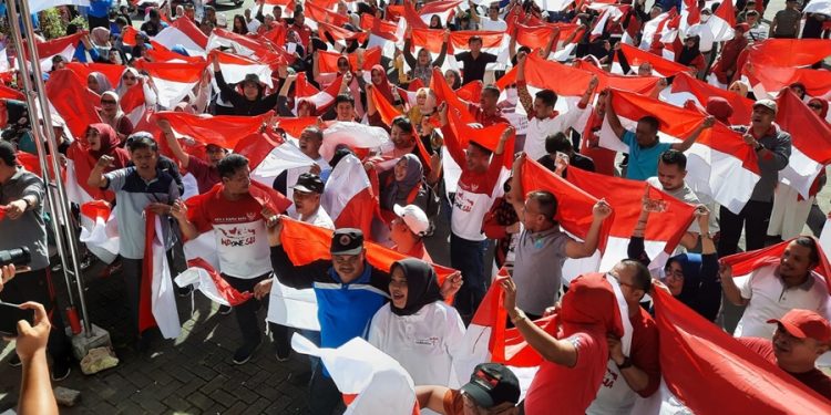  Jelang Hari Kemerdekaan RI ke 77 Pemkab Bolaang Mongondow (Bolmong) menggelar pencanangan 10 juta bendera Merah Putih. Pencanangan 10 juta bendera di Kabupaten Bolmong itu, dipimpin Penjabat Bupati Bolmong Limi Mokodompit diwakili Sekretaris Daerah Tahlis Gallang.  Kegiatan yang dilaksanakan oleh Badan Kesatuan Bangsa dan Politik ini untuk memperingati hari ulang tahun ke-77 Kemerdekaan RI. “Pencanangan ini ditandai dengan pembagian bendera ke para Camat untuk dibagikan ke desa-desa,” ujar Sekda Bolmong Tahlis Gallang. Tahlis menjelaskan, gerakan pembagian 10 juta bendera Merah Putih kepada masyarakat merupakan petunjuk dari Kementerian Dalam Negeri melalui pemerintah provinsi, kabupaten/kota dalam rangka menyemarakkan HUT Ke-77 Kemerdekaan RI. Menurutnya kegiatan ini dilaksanakan dengan pemikiran bahwa bendera Merah Putih merupakan identitas, simbol, dan alat pemersatu bangsa di seluruh wilayah NKRI. “Saya berharap setelah pencangan ini, seluruh SKPD, pimpinan instansi vertikal, BUMN, perbankan, partai politik, organisasi masyarakat, untuk berpartisipasi secara swadaya membagikan bendera Merah Putih kepada masyarakat sampai dengan tanggal 31 Agustus 2022,” tambahnya. Selain itu kegiatan ini juga sebagai ajang sosialisasi kepada pelajar, mahasiswa, ormas, partai politik dan masyarakat untuk menumbuhkan rasa nasionalisme, patriotisme dan cinta tanah air. Kepala Kesbangpol Bolmong Chris Kamasaan menjelaskan kegiatan ini dilandasi pemikiran bendera merah putih merupakan identitas dan simbol bangsa serta sebagai alat pemersatu di seluruh wilayah NKRI. “Pencanangan ini akan diikuti gerakan masif seluruh komponen di masing-masing instansi termasuk,” katanya. Menurutnya gerakan pembagian 10 juta bendera Merah Putih merupakan kegiatan nasional dengan cara menggalang partisipasi dan swadaya pemerintah, masyarakat baik secara pribadi maupun kelompok serta unsur-unsur organisasi kemasyarakatan. (*)