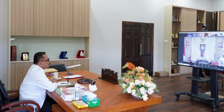 TOTABUAN.CO BOLMONG – Pj Bupati Bolaang Mongondow (Bolmong) Limi Mokodompit mengikuti rapat evaluasi dan penilaian pelaksanaan tugas penjabat (Pj) kepala daerah dengan Menteri Dalam Negeri Tito Karnavian Rabu 24 Agustus 2022. Rapat evaluasi itu dilakukan secara daring itu diikuti para Pj kepala daerah mulai gubernur, bupati walikota dari berbagai daerah. Mendagri Tito Karnavian mengatakan, penunjukan Pj. kepala daerah dilakukan berdasarkan peraturan yang berlaku. Penunjukan ini merupakan konsekuensi diterapkannya Undang-Undang (UU) Nomor 7 Tahun 2017 tentang Pemilihan Umum (Pemilu) dan UU Nomor 10 Tahun 2016 tentang Pemilihan Kepala Daerah (Pilkada). Dua UU tersebut saling terkait satu sama lain. Mendagri menyampaikan, rapat tersebut menjadi momentum untuk melakukan evaluasi terhadap sistem penyelenggaraan pemerintahan di daerah. Berdasarkan UU Nomor 10 Tahun 2016, selain diatur terkait pembatasan masa jabatan juga diatur mengenai sistem pertanggungjawaban dan pelaporan pelaksanaan tugas Pj. kepala daerah. Adapun masa jabatan Pj. kepala daerah diatur paling lama satu tahun dengan sistem pelaporan pertanggungjawabannya dilakukan setiap tiga bulan. Setiap tiga bulan Pj kepala daerah membuat laporan pertanggungjawaban. Khusus untuk penjabat gubernur laporan pertanggungjawaban kepada Presiden melalui Mendagri. “Jadi nanti dikirim suratnya kepada Presiden melalui Mendagri, dan kemudian untuk penjabat bupati/wali kota disampaikan pertanggungjawabannya kepada Mendagri melalui gubernur sekurang-kurangnya tiga bulan sekali,” kata Tito. Mendagri mendukung Pj. kepala daerah dalam menjalankan tugas sesuai dengan peraturan yang berlaku. Dia meminta kepala daerah tidak segan dan ragu untuk meminta persetujuan tertulis dari Kemendagri saat hendak menjalankan tugas. Mendagri juga mengatakan alasan pelaksanaan Pemilu presiden/wakil presiden dilakukan bersamaan dengan Pilkada Serentak pada tahun 2024. Alasan tersebut yaitu agar terjadi perencanaan dan pelaksanaan kegiatan secara paralel, antara pemerintah pusat dan pemerintah daerah, baik provinsi maupun kabupaten/kota. “Ini untuk menghindari terjadinya ketidaksesuaian antara Rencana Pembangunan Jangka Menengah lima tahunan yang terjadi dalam praktik selama ini. Tahun 2014 pemilihan presiden dan wakil presiden yang otomatis presiden terpilih membuat RPJMN lima tahunan sampai dengan 2019, di tengah-tengah itu ada Pilkada, Pilkada 2017, Pilkada lagi 2018, yang melahirkan kepala daerah-kepala daerah baru, jadi kepala daerah yang baru itu waktunya juga berbeda-beda,” ujarnya. (*)