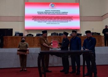 TOTABUAN.CO BOLMONG – Dewan Perwakilan Rakyat Daerah (DPRD) Kabupaten Bolaang Mongondow (Bolmong) mengesahkan Rancangan Peraturan Daerah (Ranperda) tentang Badan Usaha Milik Desa (Bumdes) menjadi Peraturan Daerah (Perda). Pengesahan itu dilakukan lewat Paripurna yang dipimpin Ketua DPRD Welty Komaling dihadiri dua wakil pimpinan DPRD serta para anggota. Rapat paripurna itu juga dihadiri Penjabat Bupati Bolmong Limi Mokodompit, Sekretaris Daerah Tahlis Gallang, para Asisten, pimpinan OPD serta Camat. Menurut Ketua DPRD Bolmong, Ranperda Bumdes yang disahkan menjadi Perda, merupakan produk atau inisiatif DPRD. “Ranperda Bumdes yang disahkan menjadi Perda ini, merupakan Ranperda Inisiatif DPRD,” ujar Welty Senin 5 September 2022. Ranperda Bumdes yang digagas DPRD Bolmong ini, dinilai sangat penting untuk memaksimalkan dalam pengelolaan badan usaha di desa. Selain itu dikatakannya, dalam rangka peningkatan penyelenggaraan pemerintahan desa, pelaksanaan pembangunan desa serta pendapatan masyarakat dan desa, agar pemerintah desa dapat mengoptimalkan sumber daya yang dimiliki sesuai kebutuhan dan potensi desa. Welty menambahkan, hadirnya Perda Bumdes, untuk memberikan kepastian hukum dan tertib dalam pendirian, pengelolaan dan pembubaran Bumdes di Kabupaten Bolmong. “Tujuan pendirian Bumdes untuk melaksanakan kegiatan usaha ekonomi melalui pengelolaan usaha, serta pengembangan investasi dan produktivitas perekonomian, dan potensi di desa,” tambahnya. Penjabat Bupati Bolmong Limi Mokodompit menyampaikan apresiasi atas kerja keras DPRD yang berhasil melahirkan produk hukum tentang Bumdes. Ia menambahkan, DPRD yang memiliki tugas sebagai legislasi telah menunjukan komitmen, dalam mengarahkan, memberikan kepastian hukum terkait pengelolaan Bumdes di desa. Bumdes adalah badan usaha yang bercirikan desa yang akan membantu penyelenggaraan pemerintahan desa dan untuk memenuhi kebutuhan masyarakat desa,” kata Limi. Selain itu, setelah disahkan, Bumdes sudah bisa melakukan kegiatan pelayanan umum melalui penyediaan barang atau jasa serta pemenuhan kebutuhan umum masyarakat desa. Yang bertujuan untuk keuntungan dalam rangka peningkatan pendapatan asli desa untuk melakukan pengembangkan usaha sebesar-besarnya sebagai sumber ekonomi masyarakat. Diketahui, selain telah menetapkan satu Perda inisiatif, DPRD juga telah membahas tigas Ranperda inisiatif lainnya. Yakni Ranperda tentang Haji, Ranperda tentang Kepemudaan dan Ranperda kedudukan protokoler, hak keuangan dan administratif pimpinan dan anggota DPRD. Rapat Paripurna DPRD itu dilakukan penyampaian perubahan Kebijakan Umum Anggaran (KUA) serta Prioritas Plafon Anggaran Sementara (PPAS) APBD Tahun Anggaran 2022. (*)