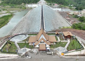 TOTABUAN.CO BOLMONG – PT Pembangunan Perumahan (PT PP) (Persero) Tbk optimis menuntaskan proyek Bendungan yang berada di Desa Pindol, Kecamatan Lolak, Kabupaten Bolaang Mongondow (Bolmong) akhir tahun ini. Hal tersebut berdasarkan progress pekerjaan yang saat telah mencapai 96%. Menurut Johan Mirdadi, saat ini pekerjaan tinggal fokus pada pekerjaan finishing. “Akhir tahun ini bisa tuntas,” kata Johan Jumat 21 Oktober 2022.   Bendungan Lolak merupakan Proyek Strategis Nasional (PSN) satu dari 45 proyek bendungan yang dicanangkan pemerintah Presiden Joko Widodo. Bendungan tersebut yang terletak di area pengembangan Kawasan Industri Bolaang Mongondow (KIMONG), yang diharapkan menjadi penggerak roda perekonomian Provinsi Sulawesi Utara khususnya di Kabupaten Bolmong ke depan. PT PP sendiri merupakan kontraktor utama dengan pekerjaan terdiri atas dua paket. Paket I yang dikerjakan sendiri oleh PT PP. Yakni pembangunan bendungan dengan lingkup pekerjaan, yaitu pekerjaan galian, pekerjaan timbunan bendungan utama, pekerjaan temporary cofferdam, pekerjaan timbunan main cofferdam, dan pekerjaan instrumentasi. Kerja Sama Operasi (KSO) perseroan dengan ASHFRI juga mendapatkan pekerjaan paket II meliputi pekerjaan timbunan bendungan utama, pekerjaan bangunan pengelak, pekerjaan bangunan pelimpah, pekerjaan bangunan intake, pekerjaan perkuatan tumpuan kiri, pekerjaan saddle dam I dan II, pekerjaan relokasi jalan dan jembatan provinsi, serta pekerjaan hidromekanikal. Johan menjelaskan, Bendungan Lolak dapat mengaliri air irigasi untuk daerah seluas 2.214 hektare dan menjadi sumber penyediaan air baku 500 liter per detik (lpd). Bendungan Lolak juga akan berfungsi sebagai pembangkit listrik dari air keluaran (outflow) waduk dengan potensi listrik sebesar 2.43 MW, pengendali banjir dengan prediksi mereduksi debit banjir sebesar 12%. “Yang menarik Bendungan Loak ini juga akan menjadi destinasi wisata baru di daerah Bolaang Mongondow," katanya.. Dengan kondisi geografi wilayah dan geoteknik lahan yang menantang, PT PP dituntut harus bekerja keras. Kondisi lahan yang beragam di lokasi yang akan dibangun juga menuntut perseroan untuk mengedepankan keahliannya dalam mengerjakan konstruksi proyek bendungan tersebut. Kehadiran bendungan dengan tipe zonal inti tegak dengan daya tampung hingga 6,1 juta per meter kubik ini, menurut dia, bakal memberikan banyak manfaat. Semua pembangunan fasilitas Bendungan Lolak tersebut sebagai bentuk komitmen perusahaan dalam mewujudkan loyalitas tanpa batas dalam membangun negeri ini. (*)