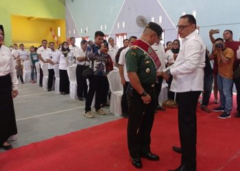 TOTABUAN.CO BOLMONG -- Audit kasus stunting, yang dirangkaikan dengan pengukuhan bapak asuh anak stunting di Kabupaten Bolaang Mongondow (Bolmong) resmi dibuka Pj Bupati Limi Mokodompit. Audit dan pengukuhan bapak asuh Stunting itu yang dilaksanakan Dinas Pengendalian Penduduk dan Keluarga Berencana itu, dihadiri Forkopimda, TP PKK Bolmong, para Asisten, serta tim percepatan penurunan dan pemerintah desa bertempat di Balai Desa Tungoi I Kecamatan Lolayan Rabu 9 November 2022. “Hari ini kita semua berada ditempat ini untuk membahas progres dalam penanganan stunting, dimana kegiatan ini merupakan media koordinasi tim percepatan penurunan stunting di Kabupaten Bolmong, yang melibatkan pemerintah, swasta maupun organisasi kemasyarakatan,” kata Limi. Pada pengukuhan bapak asuh Stunting Ketua DPRD Bolmong Welty Komaling, Dandim 1303 Bolmong Letkol Topan Angker S.Sos dan pimpinan Bank SulutGo Cabang Lolak David Yunus dikukuhkan sebagai bapak asuh anak Stunting Kabupaten Bolmong. “Semoga ini akan menambah energi dan semangat baru bagi pemerintah daerah dan seluruh stakeholder di Kabupaten Bolmong, untuk bersama-sama menekan angka stunting sebagaimana yang kita harapkan bersama,” kata Limi. Stunting atau sering disebut sebagai kondisi gagal tumbuh pada anak akibat kekurangan gizi kronis, merupakan masalah nasional yang hingga kini masih terus diupayakan oleh pemerintah pusat dan daerah. Termasuk di Kabupaten Bolmong. Sebab prevalensi stunting dalam 10 tahun terakhir menunjukkan bahwa stunting merupakan salah satu masalah gizi terbesar pada balita di Indonesia, berdasarkan hasil riset kesehatan dasar Tahun 2018. Limi mengatakan, permasalahan stunting tidak hanya dipengaruhi oleh gizi anak saja, namun juga dipengaruhi oleh faktor-faktor lainnya antara lain pola asuh anak, ketersedian air bersih layak minum, jamban sehat dan lain sebagainya, sehingga dalam penanganan dan  pencegahannya pun harus dilakukan secara menyeluruh atau konvergen. Persoalan stunting di Kabupaten Bolmong menjadi salah satu fokus program bidang kesehatan. Guna mengantisipasi kondisi gizi kronis yang mengakibatkan anak tumbuh dengan kondisi yang tidak maksimal, salah satu cara untuk mengantisipasi dan menangani permasalahan stunting yaitu dengan melaksanakan audit kasus stunting. Audit ini kata Limi, merupakan upaya identifikasi resiko dan penyebab resiko, pada kelompok sasaran berbasis survei langsung rutin atau sumber data lainnya. Termasuk mengatasi masalah mendasar pada kelompok sasaran yaitu calon pengantin, ibu hamil, ibu menyusui, ibu nifas, bayi dua tahun dan balita. Kegiatan ini juga untuk membahas progres dalam penanganan stunting. Tim percepatan penurunan stunting Kabupaten Bolmong yang melibatkan pemerintah, swasta maupun organisasi kemasyarakatan, diharapkan melalui audit ini, akan menyamakan persepsi dan membangun komitmen kita untuk bersama-sama mencari solusi dan berbuat terbaik bagi Kabupaten Bolmong. Limi mengatakan, percepatan penurunan stunting tidak dapat dilakukan sendiri-sendiri, tetapi harus bersama-sama dengan semua pemangku kepentingan terkait. “Saya mengajak kita semua untuk merapatkan barisan dalam mendukung upaya pemerintah untuk percepatan penurunan stunting dalam aksi nyata. Sehingga akan terwujud generasi baru yang sehat, cerdas dan berkualitas baik dari segi fisik maupun mental,” katanya. (*)