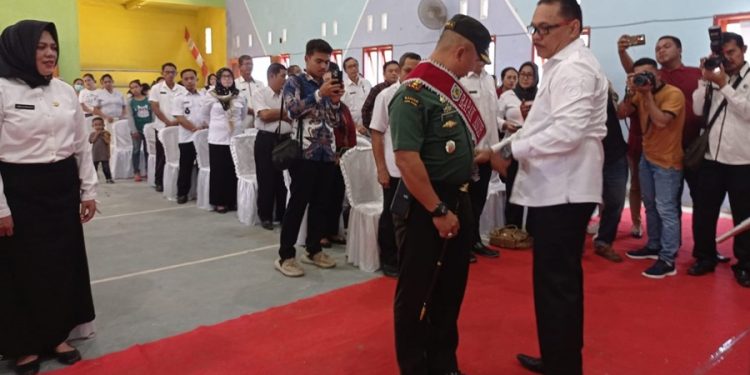 TOTABUAN.CO BOLMONG -- Audit kasus stunting, yang dirangkaikan dengan pengukuhan bapak asuh anak stunting di Kabupaten Bolaang Mongondow (Bolmong) resmi dibuka Pj Bupati Limi Mokodompit. Audit dan pengukuhan bapak asuh Stunting itu yang dilaksanakan Dinas Pengendalian Penduduk dan Keluarga Berencana itu, dihadiri Forkopimda, TP PKK Bolmong, para Asisten, serta tim percepatan penurunan dan pemerintah desa bertempat di Balai Desa Tungoi I Kecamatan Lolayan Rabu 9 November 2022. “Hari ini kita semua berada ditempat ini untuk membahas progres dalam penanganan stunting, dimana kegiatan ini merupakan media koordinasi tim percepatan penurunan stunting di Kabupaten Bolmong, yang melibatkan pemerintah, swasta maupun organisasi kemasyarakatan,” kata Limi. Pada pengukuhan bapak asuh Stunting Ketua DPRD Bolmong Welty Komaling, Dandim 1303 Bolmong Letkol Topan Angker S.Sos dan pimpinan Bank SulutGo Cabang Lolak David Yunus dikukuhkan sebagai bapak asuh anak Stunting Kabupaten Bolmong. “Semoga ini akan menambah energi dan semangat baru bagi pemerintah daerah dan seluruh stakeholder di Kabupaten Bolmong, untuk bersama-sama menekan angka stunting sebagaimana yang kita harapkan bersama,” kata Limi. Stunting atau sering disebut sebagai kondisi gagal tumbuh pada anak akibat kekurangan gizi kronis, merupakan masalah nasional yang hingga kini masih terus diupayakan oleh pemerintah pusat dan daerah. Termasuk di Kabupaten Bolmong. Sebab prevalensi stunting dalam 10 tahun terakhir menunjukkan bahwa stunting merupakan salah satu masalah gizi terbesar pada balita di Indonesia, berdasarkan hasil riset kesehatan dasar Tahun 2018. Limi mengatakan, permasalahan stunting tidak hanya dipengaruhi oleh gizi anak saja, namun juga dipengaruhi oleh faktor-faktor lainnya antara lain pola asuh anak, ketersedian air bersih layak minum, jamban sehat dan lain sebagainya, sehingga dalam penanganan dan  pencegahannya pun harus dilakukan secara menyeluruh atau konvergen. Persoalan stunting di Kabupaten Bolmong menjadi salah satu fokus program bidang kesehatan. Guna mengantisipasi kondisi gizi kronis yang mengakibatkan anak tumbuh dengan kondisi yang tidak maksimal, salah satu cara untuk mengantisipasi dan menangani permasalahan stunting yaitu dengan melaksanakan audit kasus stunting. Audit ini kata Limi, merupakan upaya identifikasi resiko dan penyebab resiko, pada kelompok sasaran berbasis survei langsung rutin atau sumber data lainnya. Termasuk mengatasi masalah mendasar pada kelompok sasaran yaitu calon pengantin, ibu hamil, ibu menyusui, ibu nifas, bayi dua tahun dan balita. Kegiatan ini juga untuk membahas progres dalam penanganan stunting. Tim percepatan penurunan stunting Kabupaten Bolmong yang melibatkan pemerintah, swasta maupun organisasi kemasyarakatan, diharapkan melalui audit ini, akan menyamakan persepsi dan membangun komitmen kita untuk bersama-sama mencari solusi dan berbuat terbaik bagi Kabupaten Bolmong. Limi mengatakan, percepatan penurunan stunting tidak dapat dilakukan sendiri-sendiri, tetapi harus bersama-sama dengan semua pemangku kepentingan terkait. “Saya mengajak kita semua untuk merapatkan barisan dalam mendukung upaya pemerintah untuk percepatan penurunan stunting dalam aksi nyata. Sehingga akan terwujud generasi baru yang sehat, cerdas dan berkualitas baik dari segi fisik maupun mental,” katanya. (*)