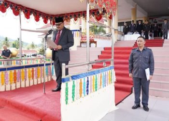 TOTABUAN.CO BOLMONG - Penjabat Bupati Bolaang Mongondow (Bolmong) Limi Mokodompit, menjadi Irup upacara peringatan Hari Pahlawan Kamis 10 November 2022. Upacara yang dilaksanakan di halaman Kantor Bupati Bolmong  ini, dihadiri Ketua DPRD Bolmong Welty Komaling, Forkopimda Sekda Tahlis Gallang, para Asisten, para kepala SKPD di lingkup Pemkab Bolmong. Upacara peringatan Hari Pahlawan itu, Pj Bupati Bolmong Limi Mokodompit membacakan amanat Menteri Sosial Republik Indonesia. "Hari Pahlawan setiap tahun kita peringati dengan renungan yang sungguh-sungguh, untuk menemukan kembali jejak para Pahlawan dalam hidup kita, sebagai bangsa dan negara merdeka," ucapnya. Perjuangan para pahlawan bangsa dari para pejuang yang gugur dalam pertempuran mempertahankan kemerdekaan penting kita resapi semangat dan keikhlasan mereka. "Para pejuang telah berkorban sampai tetes darah penghabisan untuk kemerdekaan yang sesungguhnya dan bukan dari pemberian siapapun melainkan berkat dan rahmat tuhan yang maha kuasa," ucapnya. Hari ini kita berada dalam perjuangan besar menaklukan ancaman dan tantangan yang nyata-nyata berada di hadapan kita. Dimana pemanasan global yang memicu berbagai bencana alam, kelangkaan pangan, energi dan air bersih. Kesiapsiagaan kita menghadapi bencana alam termasuk pandemi covid 19 serta kelangkaan sumber daya harus senantiasa diperjuangkan secara bersama dengan kesungguhan. Sehingga mari kita maju dan bergerak bersama dengan tekad untuk menang. Kita harus meneruskan pengembangan dan pemanfaatan energi baru dan terbarukan, melakukan pengembangan sumber pangan berbasiskan potensi dan kearifan lokal sebagai solusi pemenuhan kebutuhan pangan. “Teladan dari para pahlawan bangsa yang telah merasuk sukma, kiranya menjadi semangat kita di peringatan hari pahlawan tahun ini,” katanya. Usai upacara Bupati bersama jajaran melakukan pelarungan bunga di pelabuhan laut Desa Labuang Uki, guna untuk menghormati jasa para pahlawan yang gugur dalam medan pertempuran untuk merebut kemerdekaan bangsa tercinta. (*)