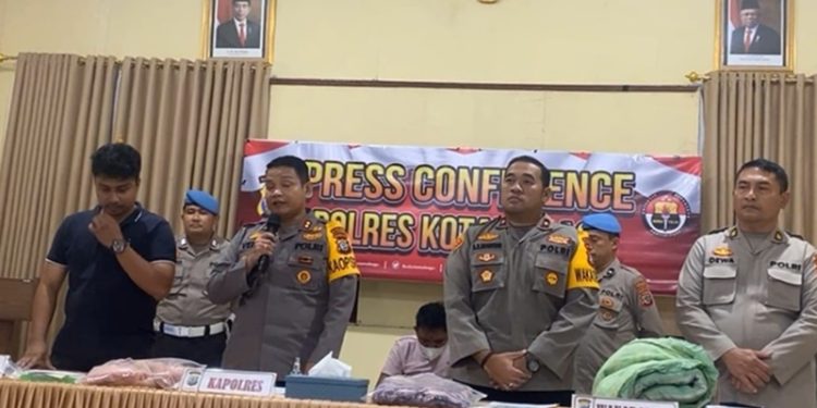 TOTABUAN.CO KOTAMOBAGU -- Kapolres Kota Kotamobagu AKBP Daveri Abdi mengatakan, tersangka pembunuhan Manda Pobela bocah perempuan berumur 5 tahun asal Desa Inuai Kecamatan Passi Barat Kabupaten Bolaang Mongondow (Bolmong) telah diamankan. Tersangka bernama Jemmy Tambanua saat ini sedang menjalani proses pemeriksaan lebih lanjut terkait dengan perbuatannya. Di hadapan wartawan Kapolres Kotamobagu AKBP Daveri Abdi mengatakan, sementara tersangka terancam hukuman 15 tahun penjara. "Untuk sementara pasal yang disangkakan kepada tersangka yakni Undang-Undang Nomor 35 tahun 2014 tentang perubahan atas Undang-Undang Nomor 23 Tahun 2002 tentang Perlindungan Anak dengan ancaman 15 tahun penjara," ucap Daveri. Konferensi pers yang digelar di Mapolres Kotamobagu itu, tampak tersangka Jemmy berada di kursi roda dengan kedua kakinya diperban akibat luka tima panas. Daveri menjelaskan, aksi pembunuhan itu dipicu sakit lantaran ayah korban kerap memutar musik dengan keras. Hal itu membuat tersangka merasa terganggu hingga melakukan aksi keji. Namun meski demikian, keterangan tersebut baru bersifat permulaan. Deveri mengatakan, penyidik masih akan terus menggali keterangan lebih jauh terhadap tersangka. Berdasarkan keterangan tersangka, sebelum dibuang, korban dicekik. Usai menghabisi kemudian membuang jasad korban ke semak-semak. "Sebelum dibuang, korban dicekik sampai meninggal. Ia panik membawa jasad korban di dalam tas kemudian diisi lagi ke dalam karung dan membuang korban di wilayah Dumoga. Tapi Ini baru keterangan awal dari tersangka.Penyidik masih akan menggali keterangan lanjutan," ujarnya. Kondisi korban setelah ditemukan kata Daveri, sudah dibawa ke rumah sakit untuk diotopsi. Saat ini sejumlah barang bukti telah diamankan seperti sprei kasur, tas makanan dan karung yang digunakan. Usai memberikan keterangan pers, tersangka Jemmy Tambanua mengaku menyesal. (*)