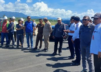 TOTABUAN.CO BOLMONG -- Pembangunan landasan pacu serta bangunan penunjang Bandara Bolaang Mongondow (Bolmong) di Desa Lalow, Kecamatan Lolak, terus menjadi perhatian serius pemerintah pusat.  Tidak terkecuali Kejaksaan Agung yang terus mengawal proyek strategis nasional yang ditargetkan akan selesai pada awal Mei 2024 mendatang. Dari pantau di lokasi proyek Rabu 7 Juni 2023, tim Kejagung meninjau proyek tersebut. Kedatangan tim yang dipimpin Kasubdit Pengamanan Pembangunan Infrastruktur Transportasi dan Telekomunikasi Direktorat  Jaksa Agung Muda Bidang Intelijen. Kedatangan mereka didampingi Pj Bupati Bolmong Limi Mokodompit, Kejari Kotamobagu Elwin Agustian Khahar Kepala Bandar Naha dan Bolmong Dwi Ariyanto serta sejumlah pimpinan OPD Pemkab Bolmong. Kepala Dinas Perhubungan Sugiarto Banteng, mengatakan pembangunan terus dilakukan sebagai langkah untuk mempercepat penyelesaian bandara yang ditargetkan selesai Mei 2024. “Jadi kedatangan tim Kejagung ke lokasi proyek Bandara, untuk mengecek progres pembangunan Bandara Bolmong,” kata kadis Perhubungan Bolmong Sugiarto Banteng. Saat ini proyek pembangunan landasan pacu sepanjang 1.600 meter yang saat ini sudah mencapai 60 persen. Selain itu beberapa kendala di lokasi proyek seperti bukit dan tiang listrik yang ada di lokasi belum dipindahkan oleh pihak PLN, padahal kurang lebih tiga tahun yang lalu Pemkab Bolmong sudah berapa kali memohon untuk tiang listrik bisa dipindahkan. “Intinya dari Kejagung minta jika ada kendala maka sampaikan kepada mereka. Insha Allah pihak Kejagung bisa membantu untuk menghubungi instansi – Instansi vertikal terkait agar supaya bisa dipercepat pembangunan bandara,” papar Sugiarto. Sugiarto menambahkan, untuk kontrak anggaran tahun 2023 ini, meliputi pembangunannya berupa terminal, parkiran dan bangunan penunjang lainnya. Ditargetkan proyek Bandara Bolmong akan diresmikan Presiden Joko Widodo. Kepala Bandara Naha dan Bolmong Dwi Ariyanto juga mengatakan bahwa untuk anggaran pembangunan bandara Bolmong tahun 2023 sebesar 203 miliar. Anggara ini kata dia, dipakai untuk lanjutan pekerjaan timbunan sisi udara atau MYC, lanjutan manajemen konstruksi pekerjaan serta bangunan dan kelengkapan lainnya. “Kita pastikan akhir bulan Desember 2023 seluruh pekerjaan selesai,” ujarnya. (*)