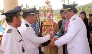 Bupati Hi Salihi Mokodongan menyerahkan piagam Penghargaan, trophy  serta uang tunai kepada sangadi pemenang Lomba Desa tingkat kabupaten Bolmong tahun 2014