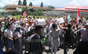 Tampak ratusan siswa yang melakukan aksi protes di depan Mapolres Bolmong menuntut status Guru mereka dicabut