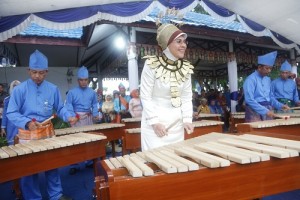 Wali Kota Tatong Bara saat menggunakan baju adat Mongondow sedang memimpin musik Kolintang